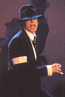  performing in black suit and fedora hat