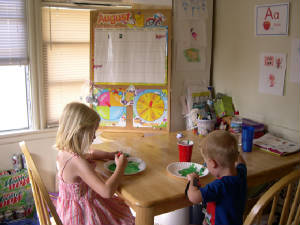 sister and brother coloring at the table
