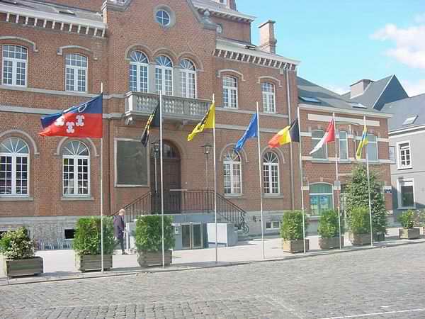 De vlaggen vóór het Lenniks gemeentehuis zijn van (v.l.n.r. ) zustergemeente Abcoude, Provincie Vlaams-Brabant, Vlaanderen, Europese Unie, België, Gemeente Lennik, zustergemeente Arconate