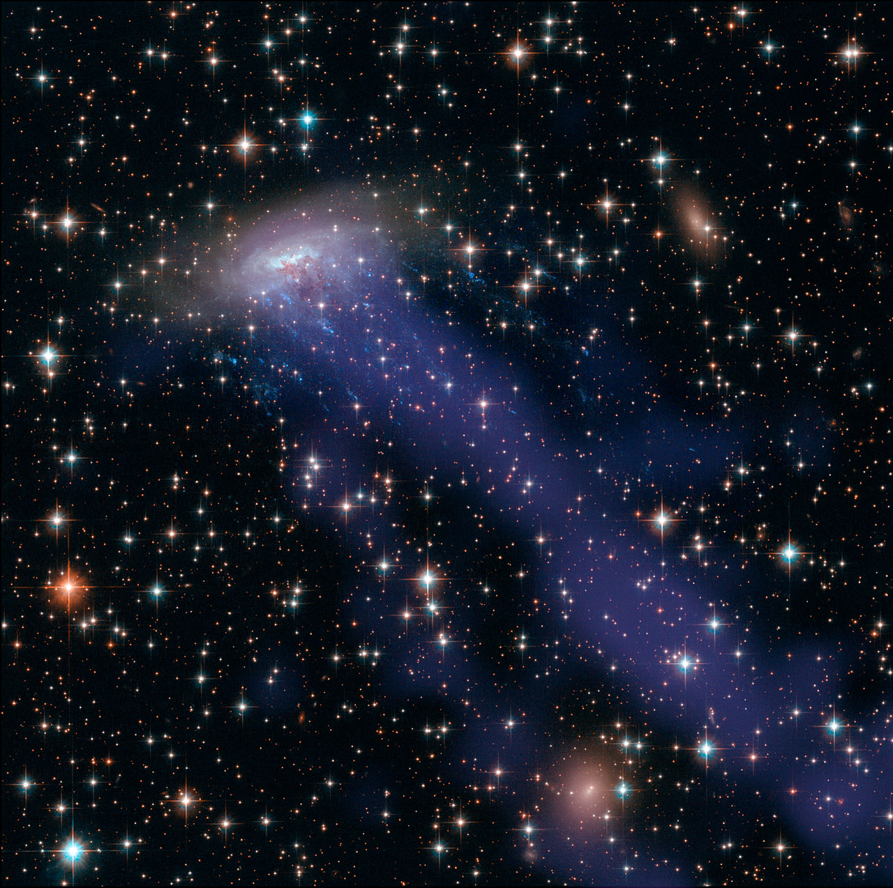  " as well as the electric blue ram pressure stripping streaks seen emanating from eso 137-001, a giant gas stream can be seen extending towards the bottom of the frame, only visible in the x-ray part of the spectrum " 