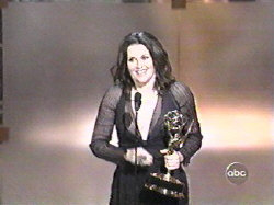 Megan Mullally, on stage, accepting her Emmy award