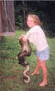 Ashley holding the 13.5 foot long python that Tim caught in his chicken pen.