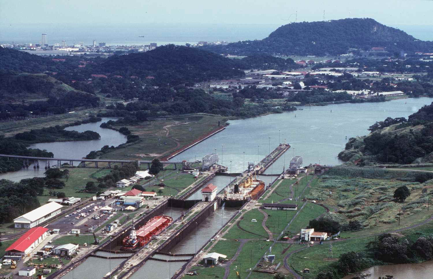 Panama Canal's Miraflores Locks (before 2000), the first set of locks for ships entering the Canal from the Pacific -- Albrook area and Ancon Hill in the right background; part of Panama City in distant left background [Photo courtesy of Panama Canal Authority from its website, www.pancanal.com]