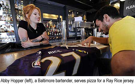 Abby Hopper, a Baltimore bartender, serves pizza for a Ray Rice jersey