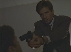 Mulder blows a chance to scare the crap out of the Cigarette-Smoking Man by not doing the very least and putting a round in the wall above his head! Punk!