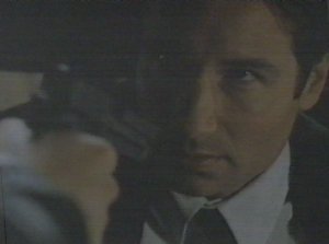 Mulder finds himself at Krycek's mercy after trying to pick up a note on the floor. I bet he wishes he'd turned on the lights before making the attempt. 