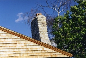 Photo of a natural stone chimney on the roof.