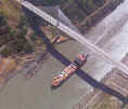 Ship transiting Culebra (Gaillard) Cut of the Panama Canal shown here under the Centennial Bridge (construction completed in 2003) located near the Pedro Miguel Locks and Paraiso townsite -- Panama Canal Authority's EL FARO newsletter