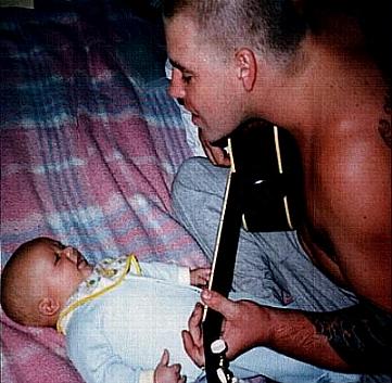 Brad playing guitar to his baby