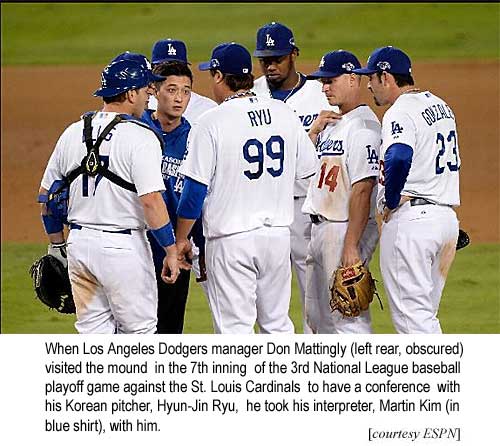 When Los Angeles Dodgers manager Don Mattingly (left rear, obscured) visited the mound in the 7th inning of the 3rd National League playoff baseball game against the St. Louis Cardinals to have a conference with his Korean pitcher, Hyun-Jin Ryu, he took his interpreter, Martin Kim (in blue shirt), with him (ESPN)