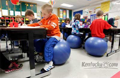 Pupils sit on big blue rubber balls in 2nd grade in Richmond