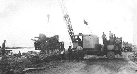 Lowering a 3-inch anti-aircraft gun into position