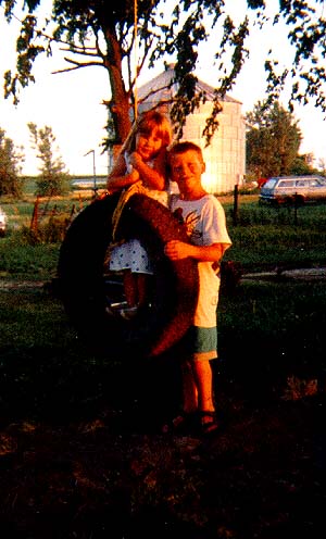 Kids on the tire swing, The grain bins and my 1973 Ford Pinto station wagon are in the background.