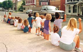 Day care children sit along Main Street in Woodstock