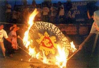 . . . Gabriela women burn the seal of the President of the Republic of the Philippines.