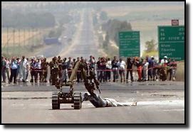 Israeli robot bomb removal machine drags badly wounded Palestinian suspected of possessing more explosives.